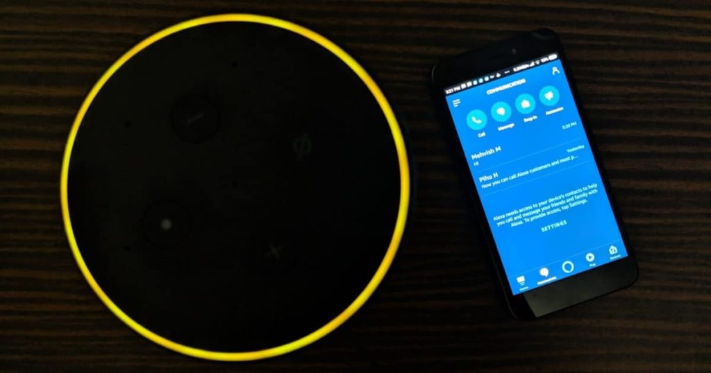 amazon echo placed on a table and flashing yellow light